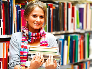 blonde haired woman holding books